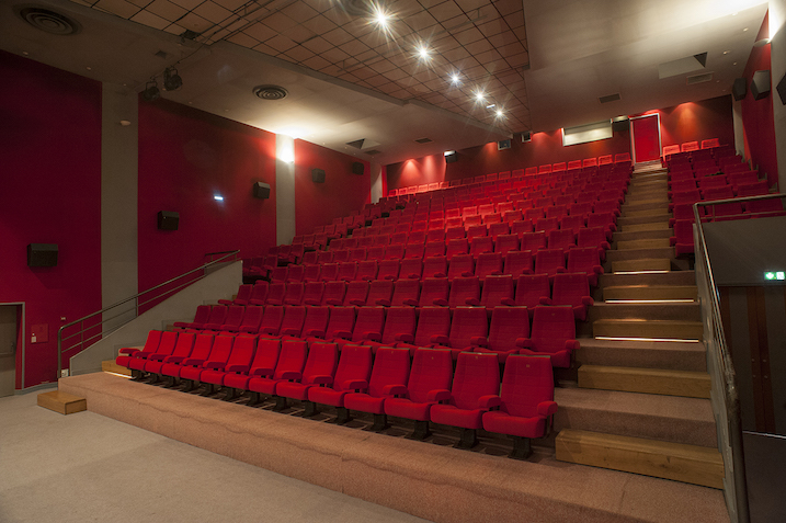 Salle de cinéma de Capdenac, avec des fauteuils rouges sur des gradins